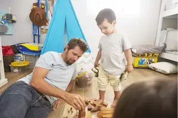 Vater und Sohn spielen im Kinderzimmer