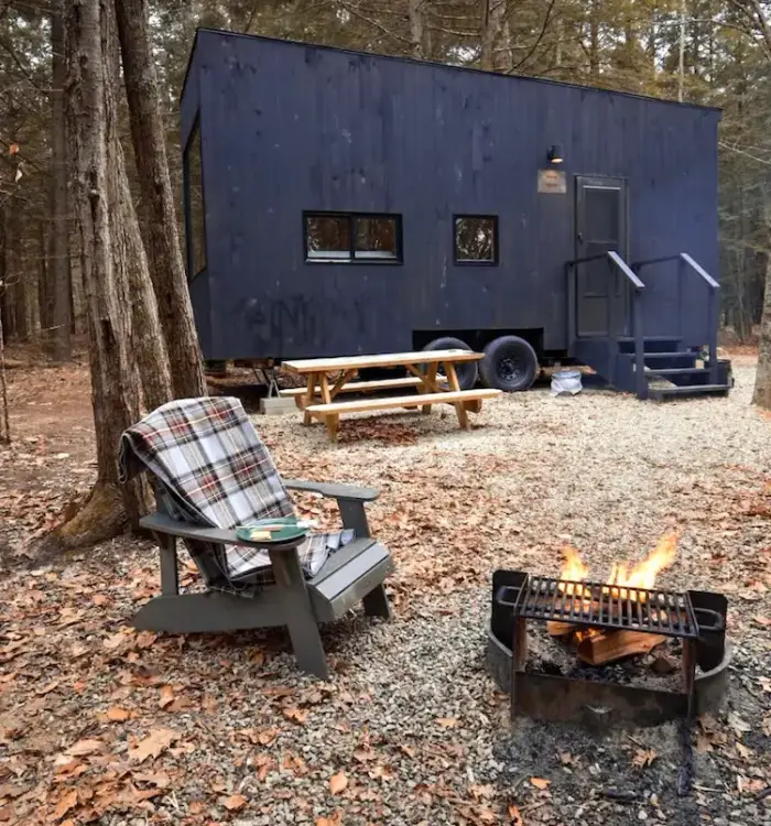 Tiny House im Wald. Devor ein Deck Chair und Lagerfeuer-grill.