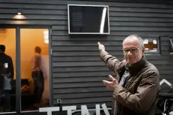 Mann zeigt auf ein an einer Wand montiertes SolarVenti Solar-Panel