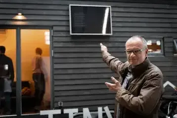 Mann zeigt auf ein an einer Wand montiertes SolarVenti Solar-Panel